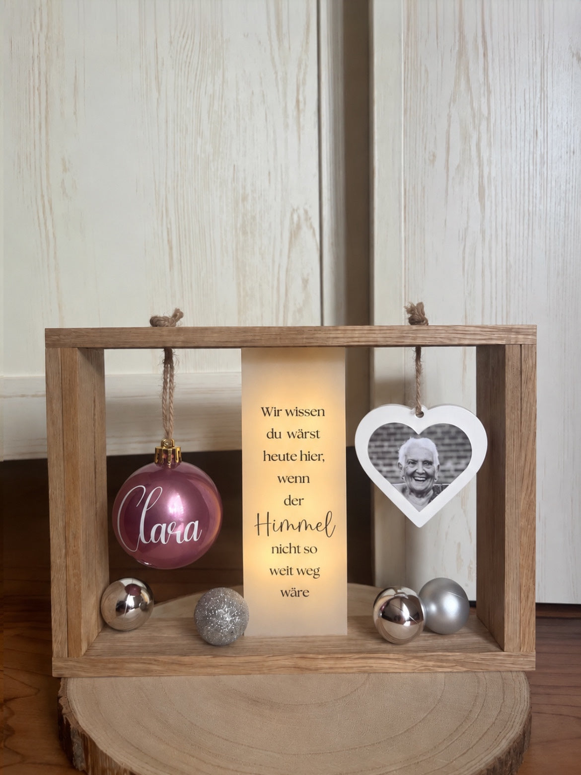 Weihnachtsandenken an Verstorbene mit Holzrahmen, Fotoherz, personalisierter Weihnachtskugel und LED-Licht im Tageslicht